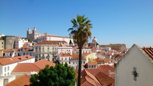 Buildings in city against clear blue sky