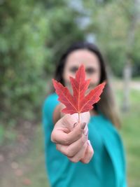 Close-up of woman holding maple leaves
