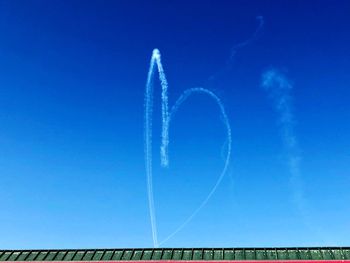 Low angle view of vapor trail against blue sky