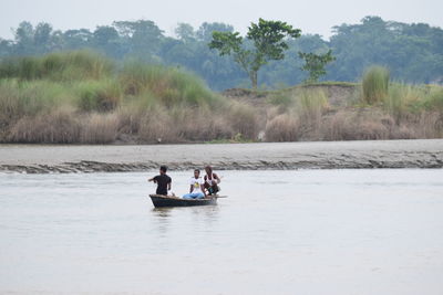 People enjoying in river against sky