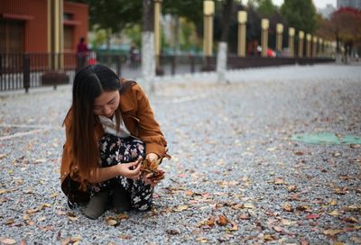 Young woman holding leaves at park