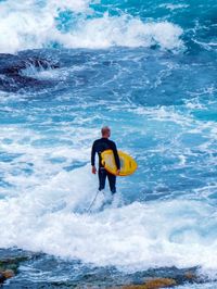 Rear view of man surfing in sea