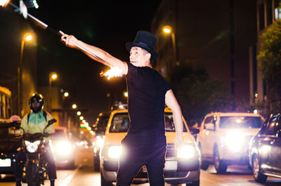 Man standing on illuminated street at night