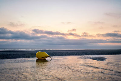 Buoy at the empty beach during the sunset