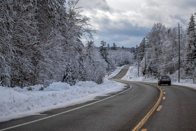 Car driving on snowy rural road in winter