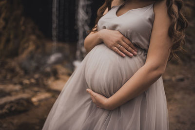 Midsection of woman sitting in forest