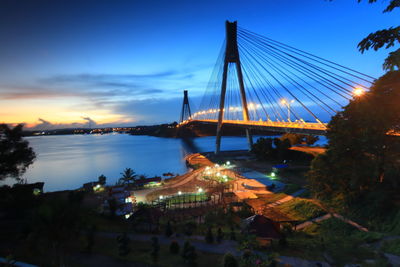 Panoramic view of illuminated bridge and city against sky at dusk