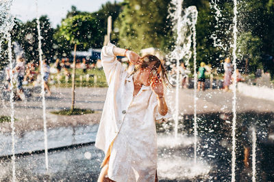 Young woman enjoying at water fountain