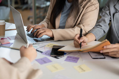 Midsection of business colleagues working on table