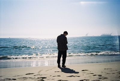 Full length of man standing on beach against sky