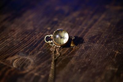 Close-up of a pocket watch on wooden table