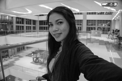 Portrait of smiling woman standing in shopping mall