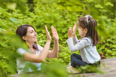 Side view of mother and daughter outdoors