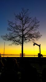 Silhouette tree by sea against sky during sunset