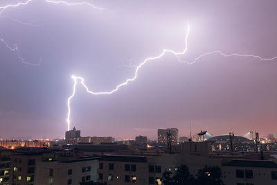 Lightning in sky above city at night