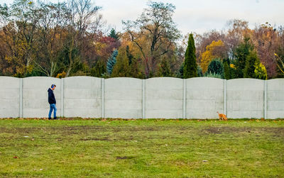 Man standing on grass against trees