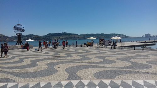 People on beach against clear sky