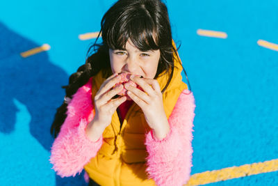 Girl eating donut while sitting on basketball court