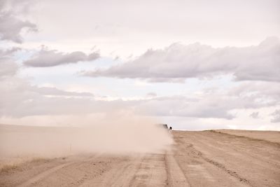 Rear view of man walking on field against sky