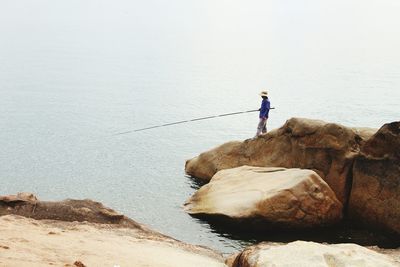 Side view of man fishing in sea
