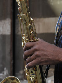 Cropped hand of musician playing saxophone outdoors