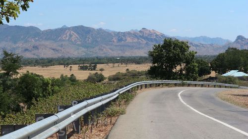 Road leading towards mountains against sky