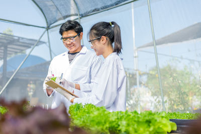 Man and woman working in greenhouse