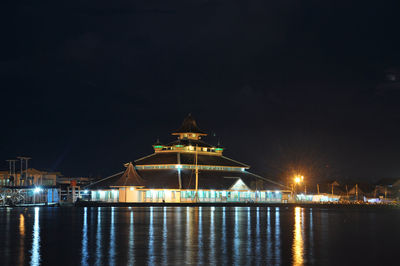 Illuminated mosque against sky at night