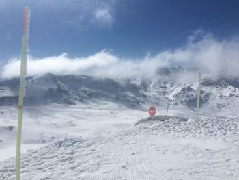 Snow covered land and mountains against sky