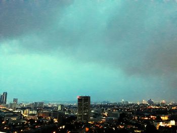 Illuminated buildings in city against sky