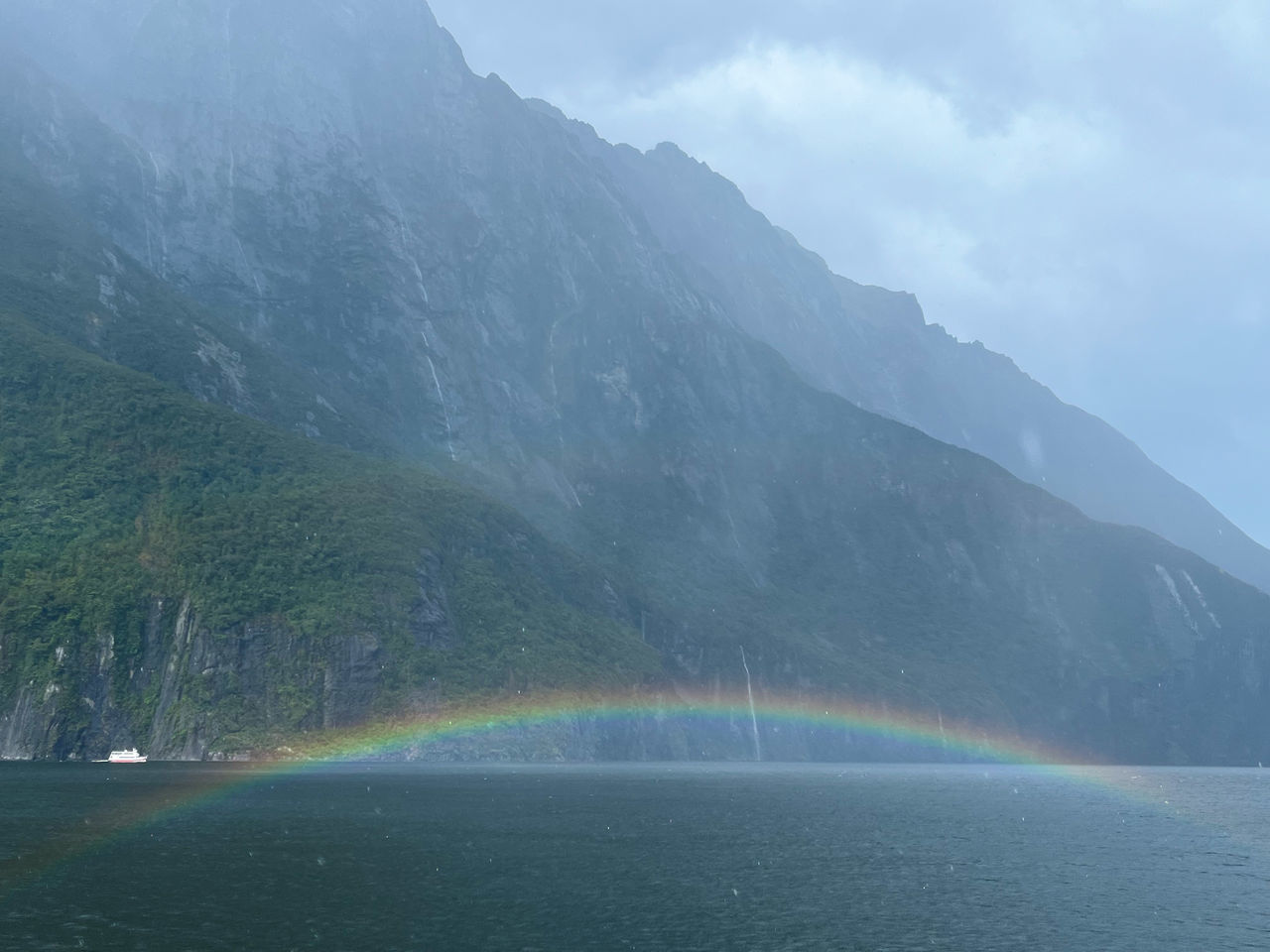 rainbow, mountain, scenics - nature, water, environment, beauty in nature, nature, landscape, land, mountain range, no people, fog, travel, lake, cloud, travel destinations, sky, multi colored, tree, tranquility, tourism, forest, cold temperature, outdoors, tranquil scene, plant, glacial landform, day, idyllic, mountain peak