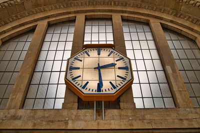 Low angle view of clock tower against wall