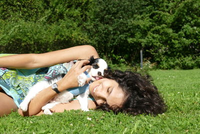 Young woman lying on grass in field