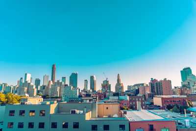 Buildings in city against blue sky