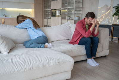 Young woman sitting on sofa at home