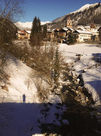 Snow covered houses by buildings against mountain