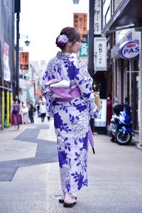 Rear view of woman standing on street