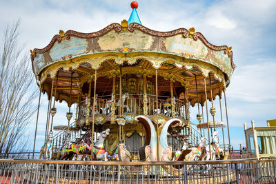 Low angle view of carousel against sky