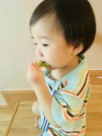 Cute boy eating food at home