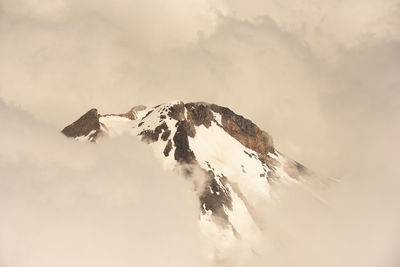 Scenic view of snowcapped mountains against cloudy sky