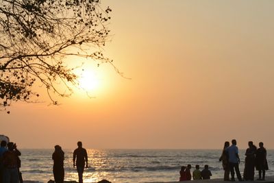 Silhouette people at beach during sunset