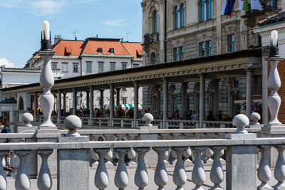 Seagull on railing against buildings in city