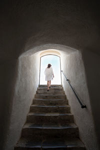 Rear view of woman walking on staircase