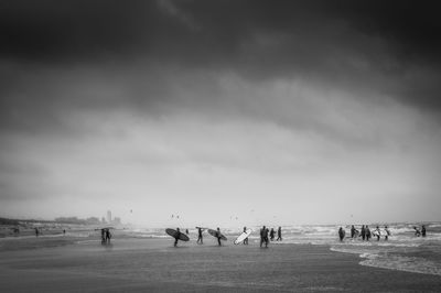 People on landscape against cloudy sky