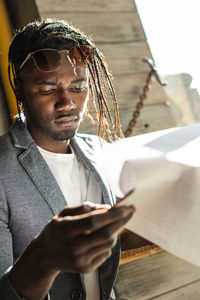 Close-up of serious young man reading menu in cafe