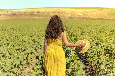 Rear view of woman standing at farm