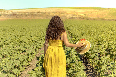 Rear view of woman standing on field