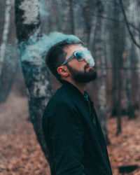 Side view of young man in forest