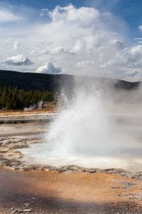 Geyser erupting in geyser basin in yellowstone national park