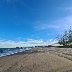 Scenic view of beach against blue sky